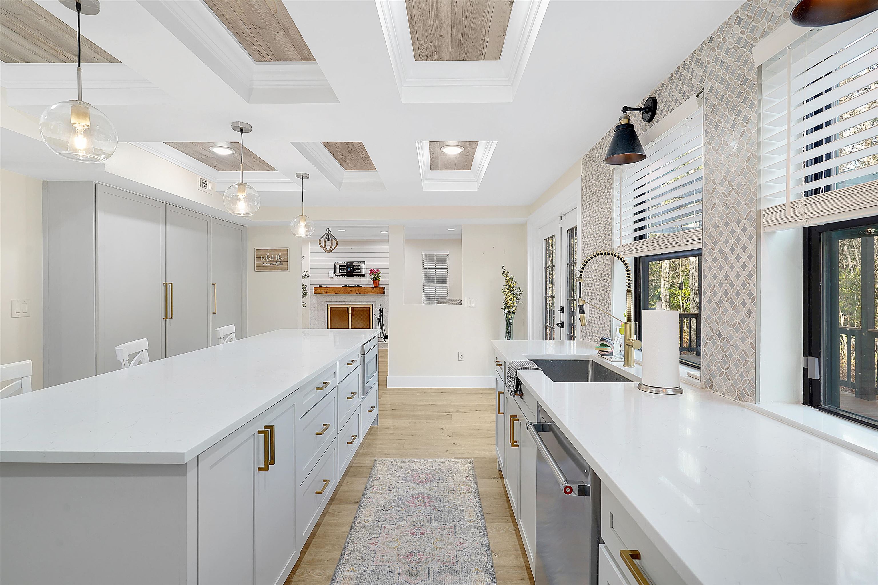 3020 Mac Road St. Augustine, FL 32086 - Photo 17 of 49 Kitchen featuring decorative light fixtures, crown molding, stainless steel dishwasher, coffered ceiling, and light wood-type flooring