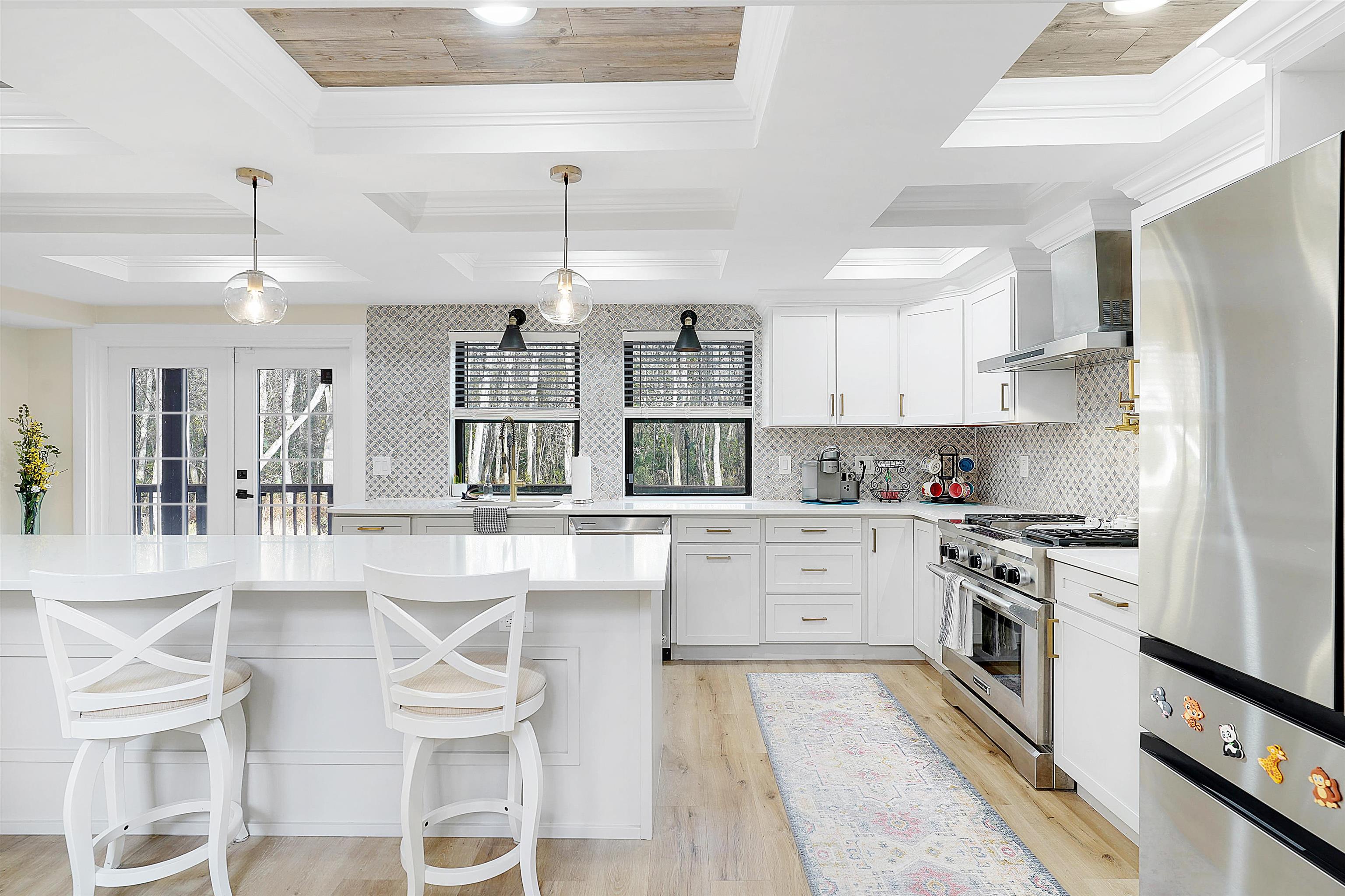3020 Mac Road St. Augustine, FL 32086 - Photo 2 of 49 Kitchen featuring stainless steel appliances, pendant lighting, a kitchen bar, coffered ceiling, and white cabinets