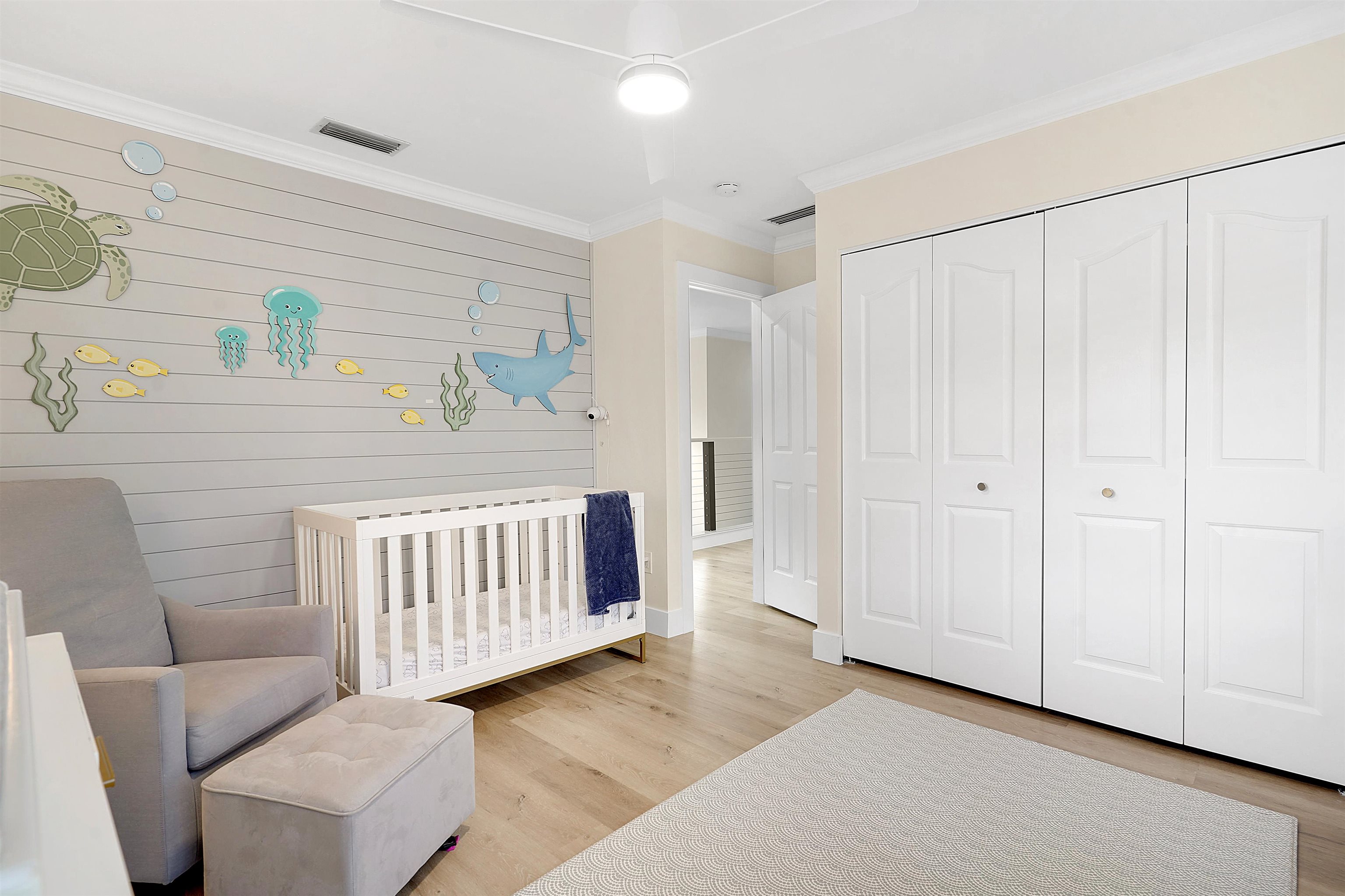 3020 Mac Road St. Augustine, FL 32086 - Photo 30 of 49 Bedroom featuring ornamental molding, a crib, light wood-style flooring, and a closet