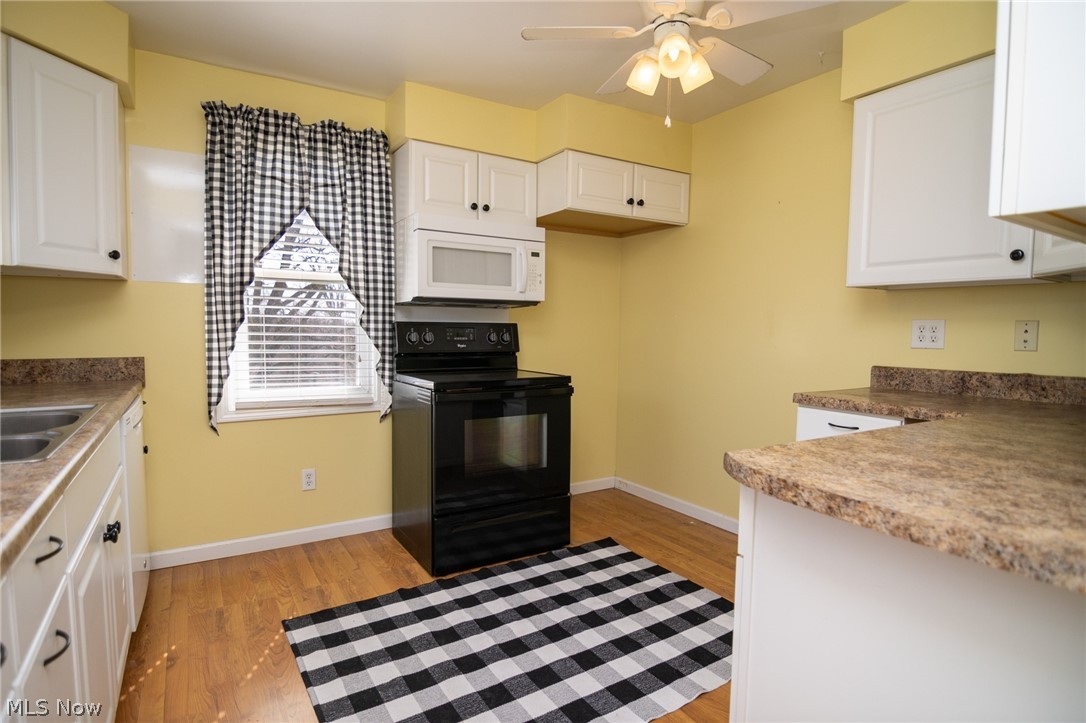 53341 Key Bellaire Road Bellaire, OH 43906 - Photo 35 of 48 Kitchen with black electric range oven, ceiling fan, white microwave, and white cabinets