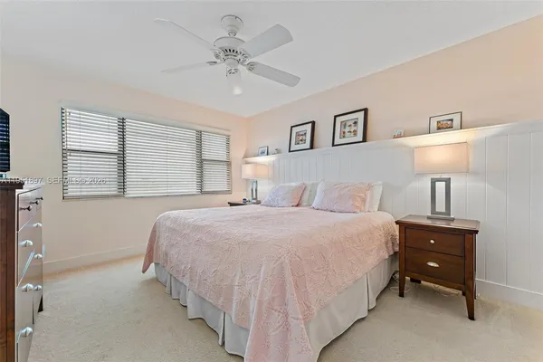 a spacious bedroom with a bed and a lamp