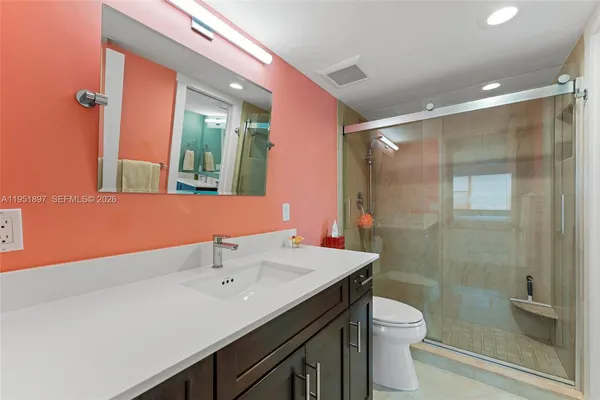 a bathroom with a sink a toilet and shower