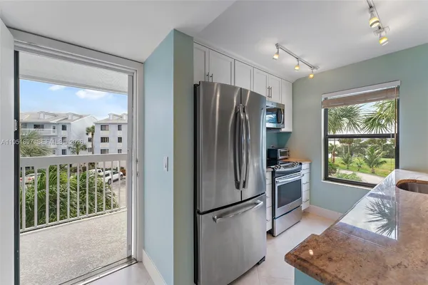 a kitchen with stainless steel appliances granite countertop a refrigerator and a stove