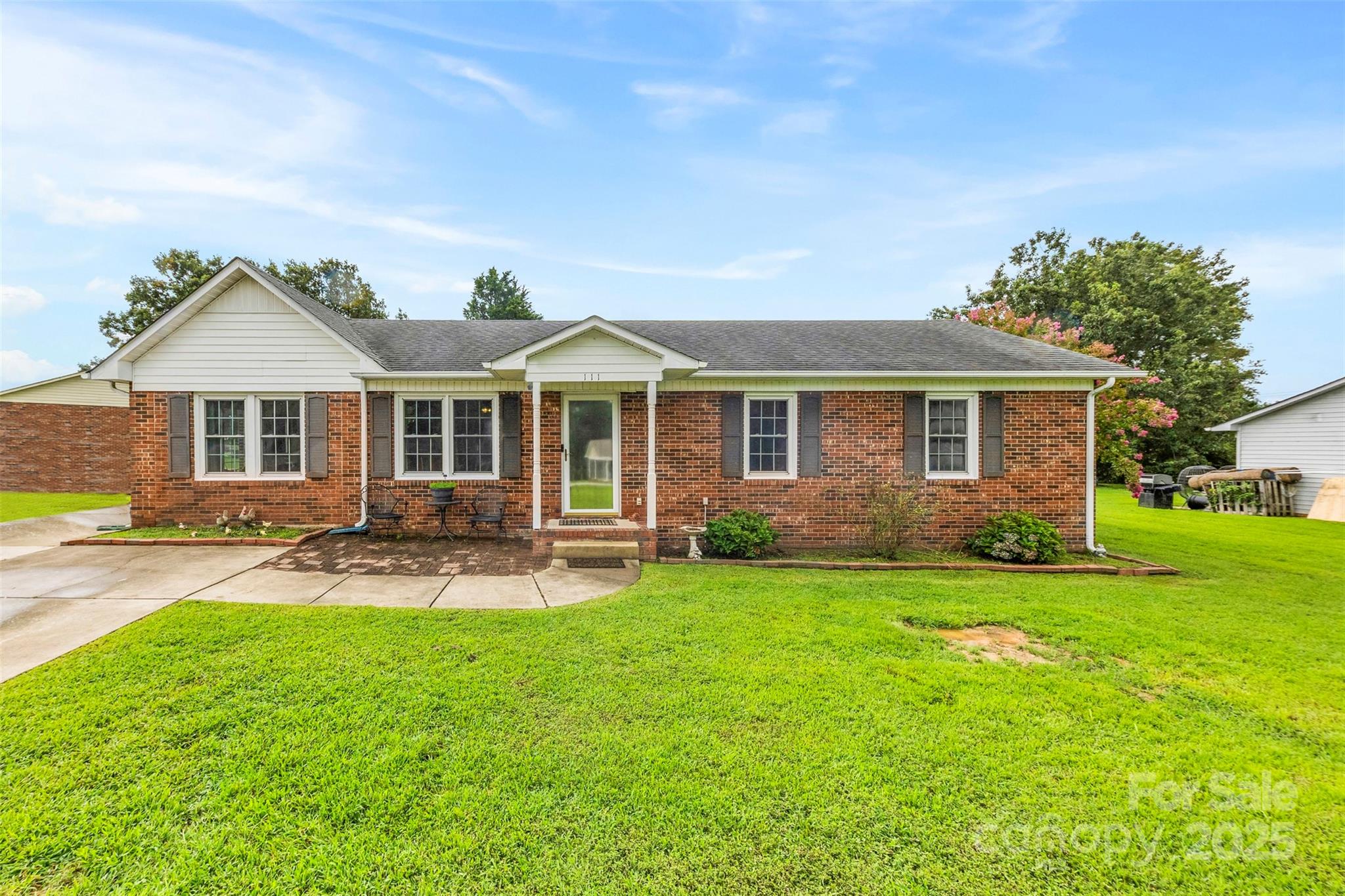 a front view of a house with a yard and trees