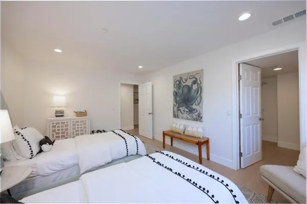 a picture of a bedroom with a bed and a lamp on dresser