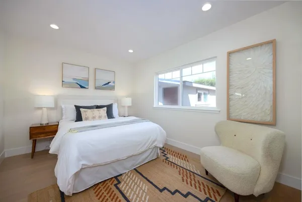 a bedroom with a bed a couch and a window