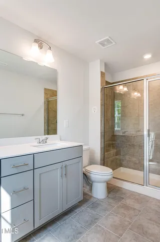 a bathroom with a double vanity sink mirror and toilet