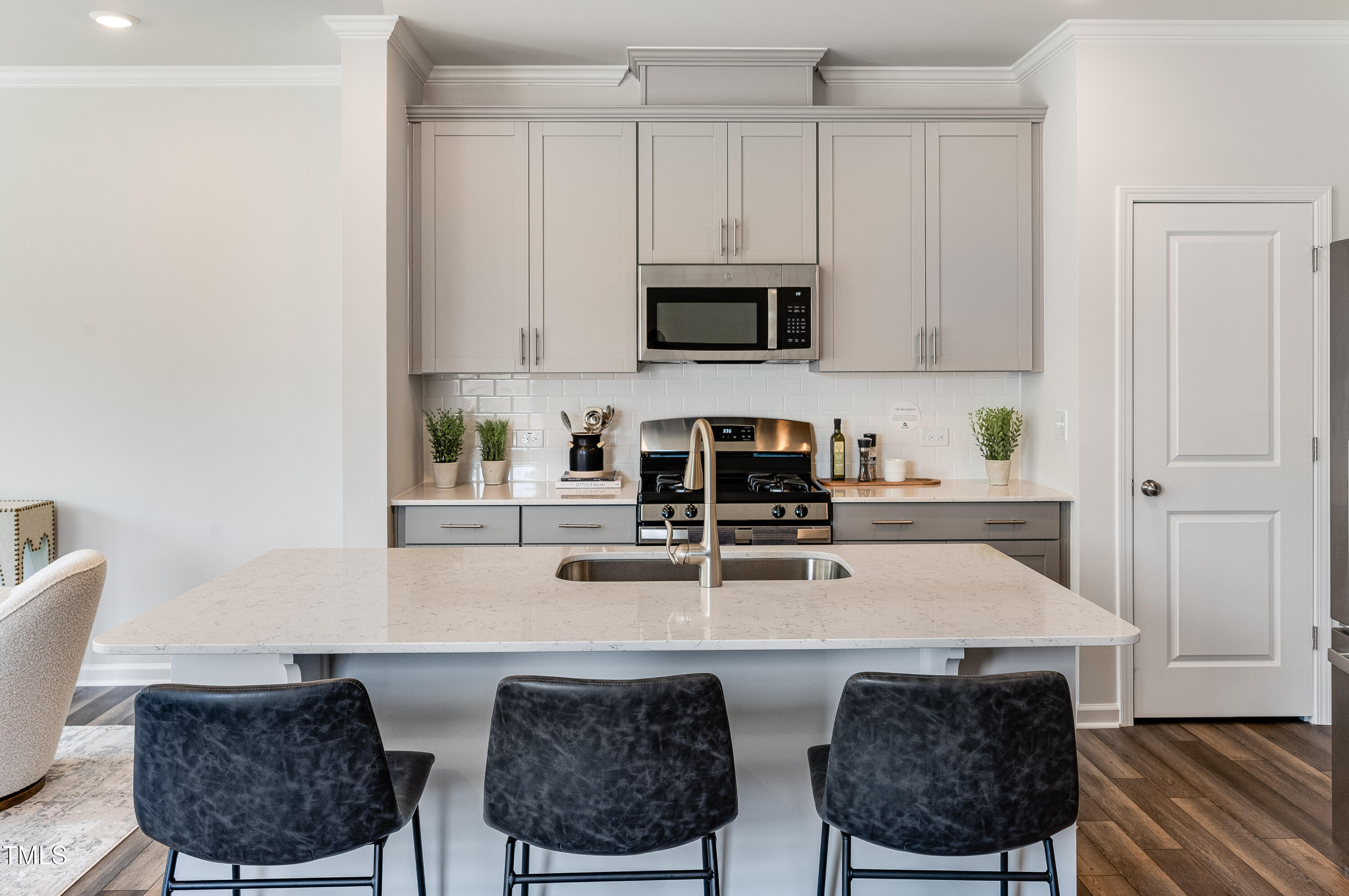 2217 Titanium Rock Road Durham, NC 27704 - Photo 5 of 27 a kitchen with stainless steel appliances a stove a sink a microwave a dining table and chairs