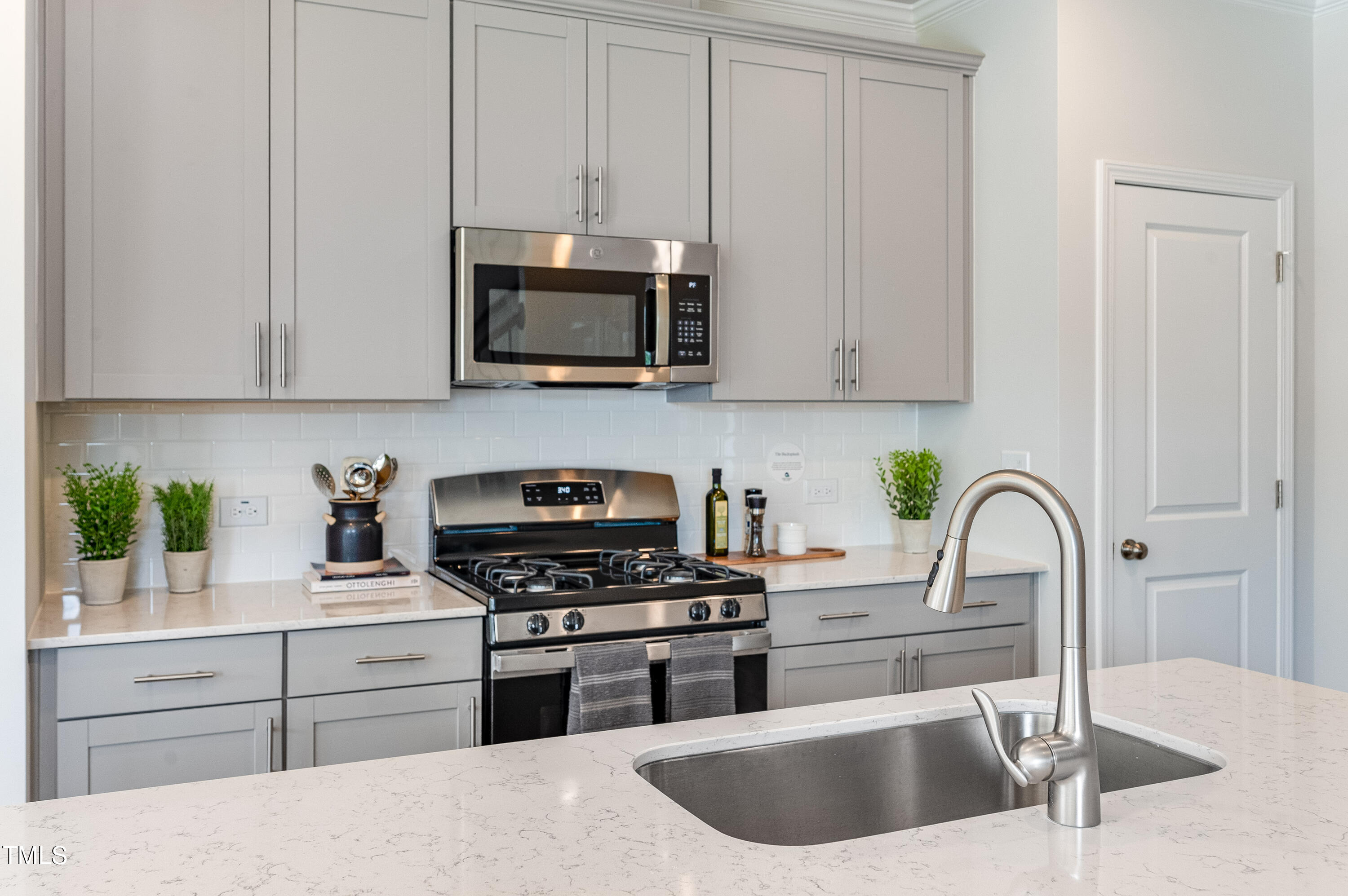2217 Titanium Rock Road Durham, NC 27704 - Photo 7 of 27 a kitchen with stainless steel appliances granite countertop a sink a stove and a microwave with wooden cabinets