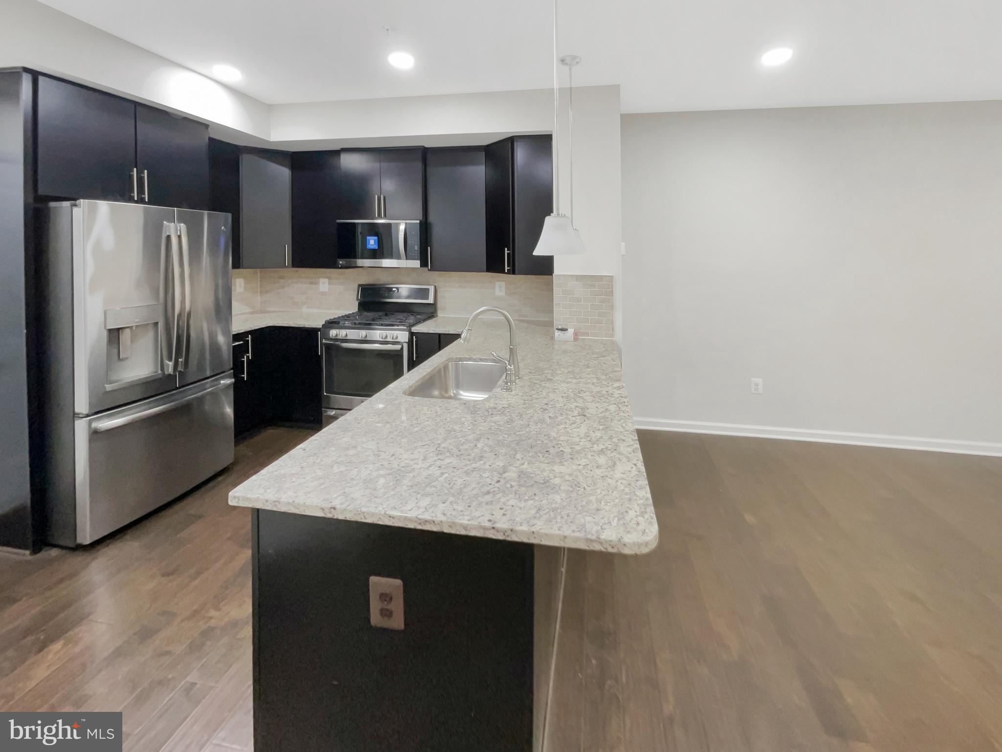 13731 Endeavour Drive Herndon, VA 20171 - Photo 6 of 37 a kitchen with kitchen island a counter top space a refrigerator and a sink