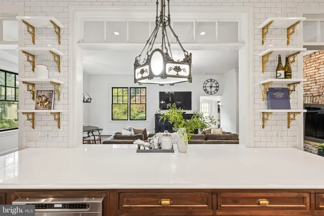 a spacious bedroom with a bed a chandelier and a dresser