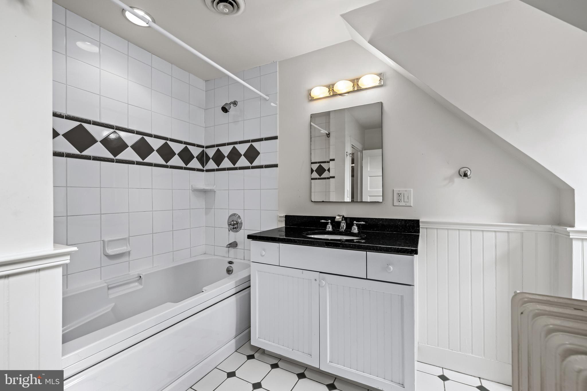 1926 Ruxton Road Ruxton, MD 21204 - Photo 78 of 108 a bathroom with a granite countertop sink a mirror and a bathtub