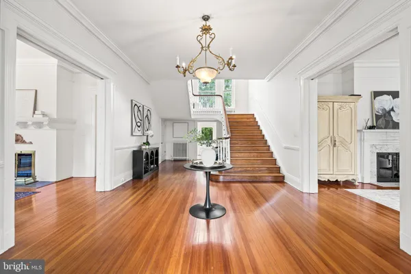 a living room with furniture two large windows and a chandelier