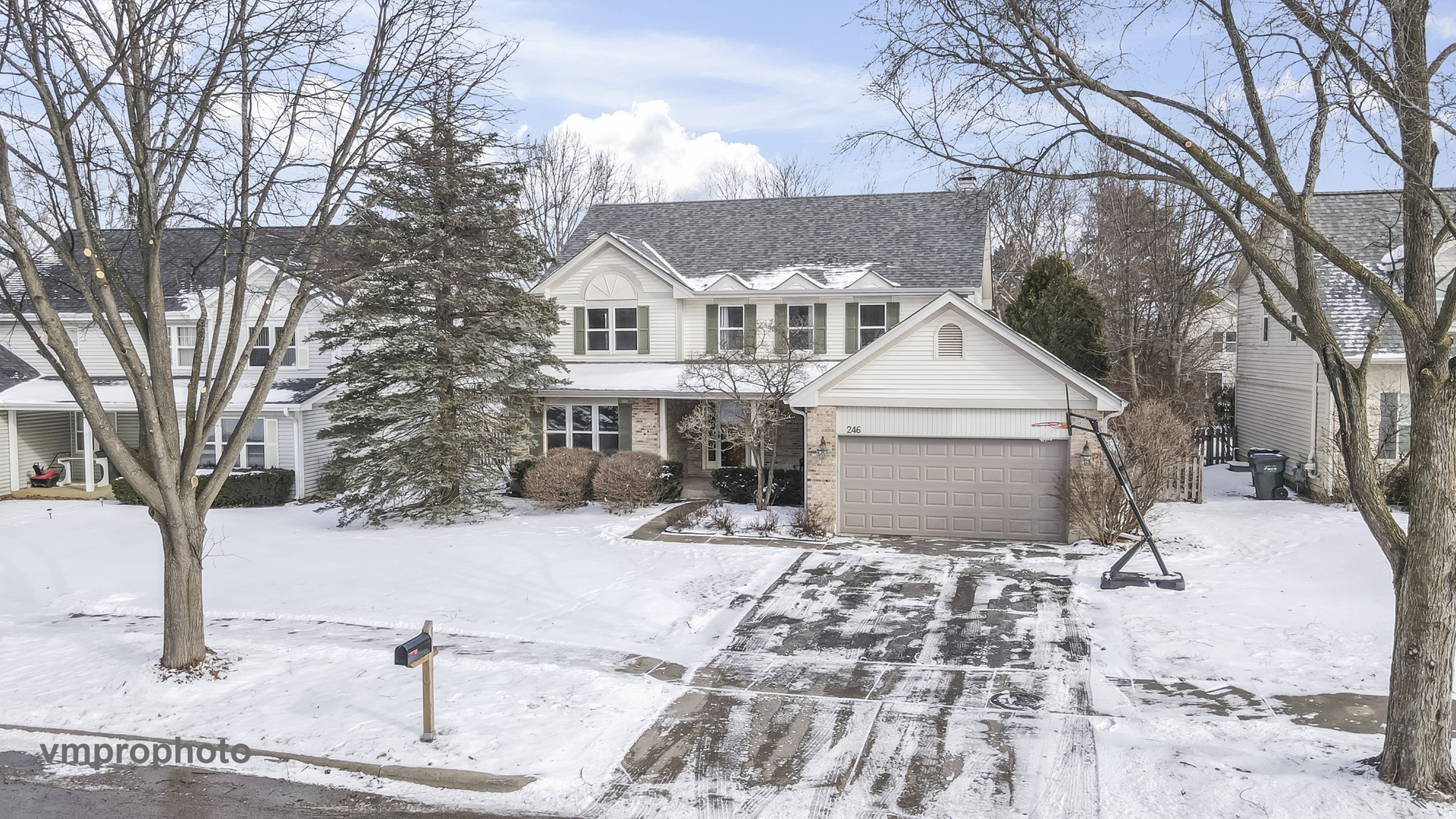 a view of a white house with a yard covered in snow
