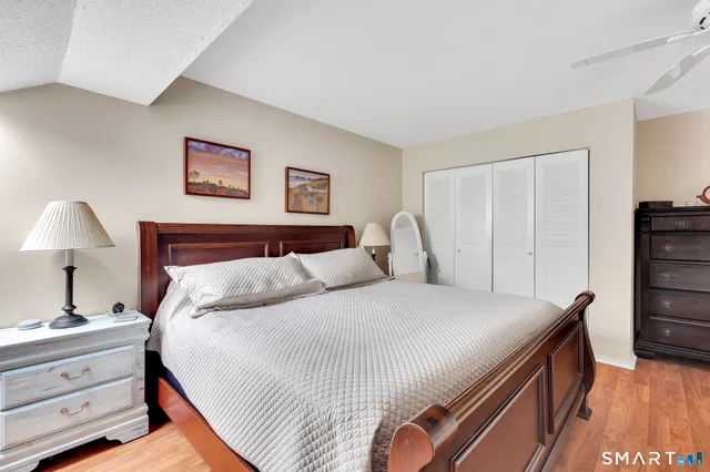 a bedroom with bed and wooden floor