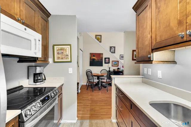 a kitchen with stainless steel appliances granite countertop a stove a sink and a microwave