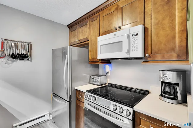 a kitchen with stainless steel appliances granite countertop a refrigerator and a stove top oven