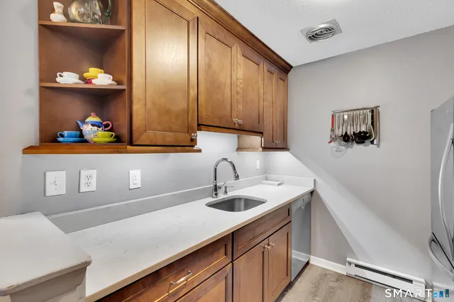 a kitchen with a sink a cabinets and wooden floor