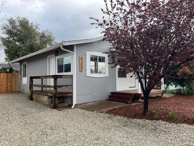 a white house that has tree in front of it