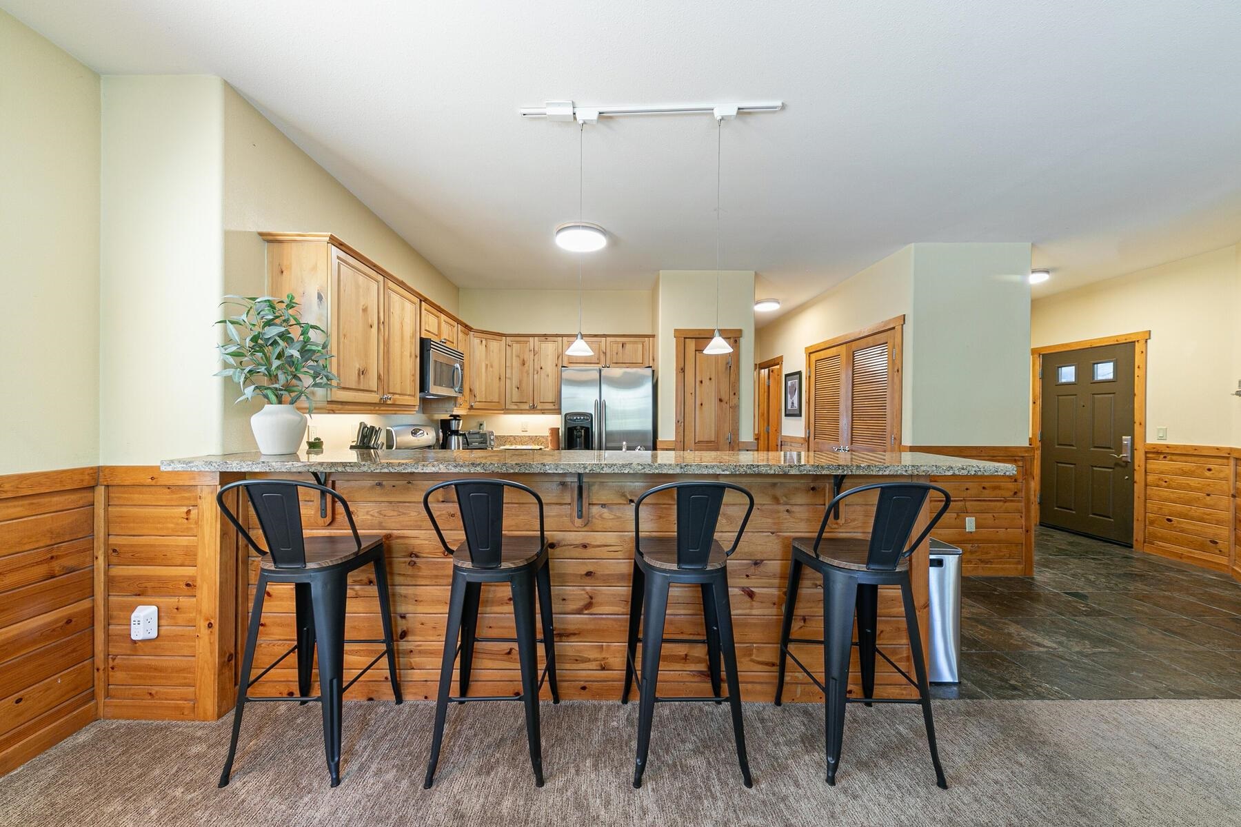 10903 Cinnabar Way, Unit 4 Truckee, CA 96161 - Photo 12 of 28 a dining area with stainless steel appliances kitchen island granite countertop a table chairs and a refrigerator
