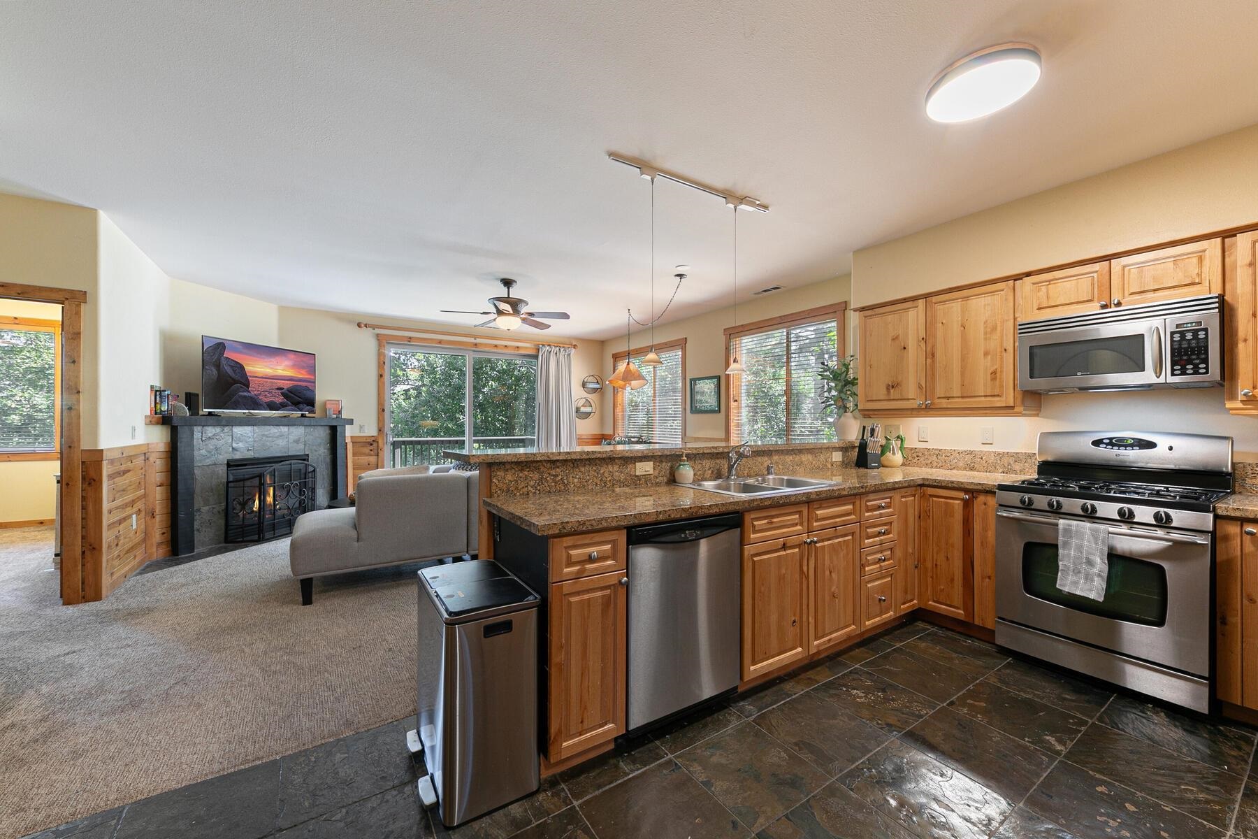 10903 Cinnabar Way, Unit 4 Truckee, CA 96161 - Photo 2 of 28 a kitchen with stainless steel appliances granite countertop a stove top oven a sink dishwasher a dining table and chairs with wooden floor