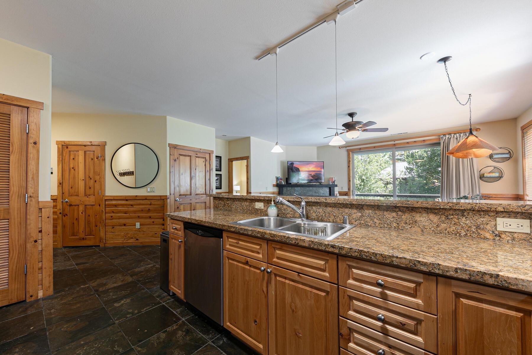 10903 Cinnabar Way, Unit 4 Truckee, CA 96161 - Photo 7 of 28 a kitchen with granite countertop a sink a window and cabinets
