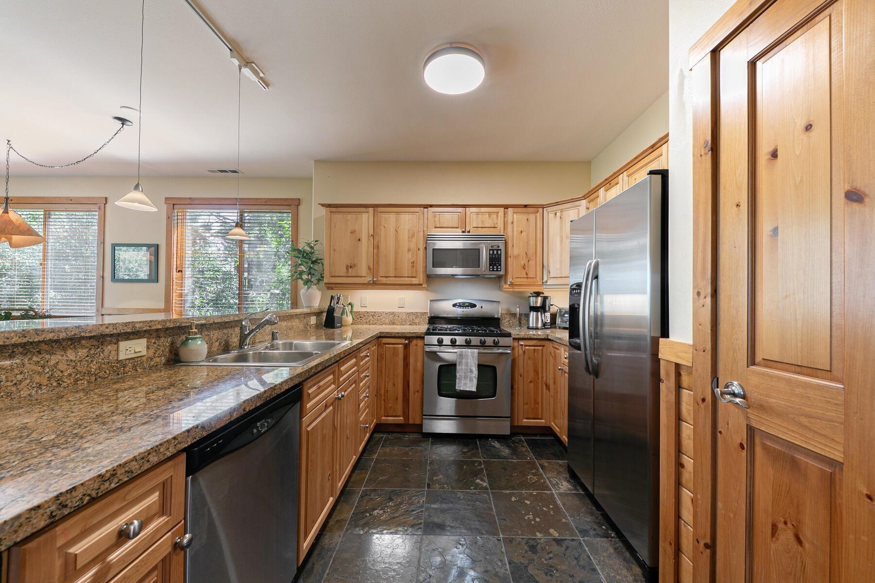 10903 Cinnabar Way, Unit 4 Truckee, CA 96161 - Photo 8 of 28 a modern kitchen with stainless steel appliances granite countertop a refrigerator a sink a stove and washer