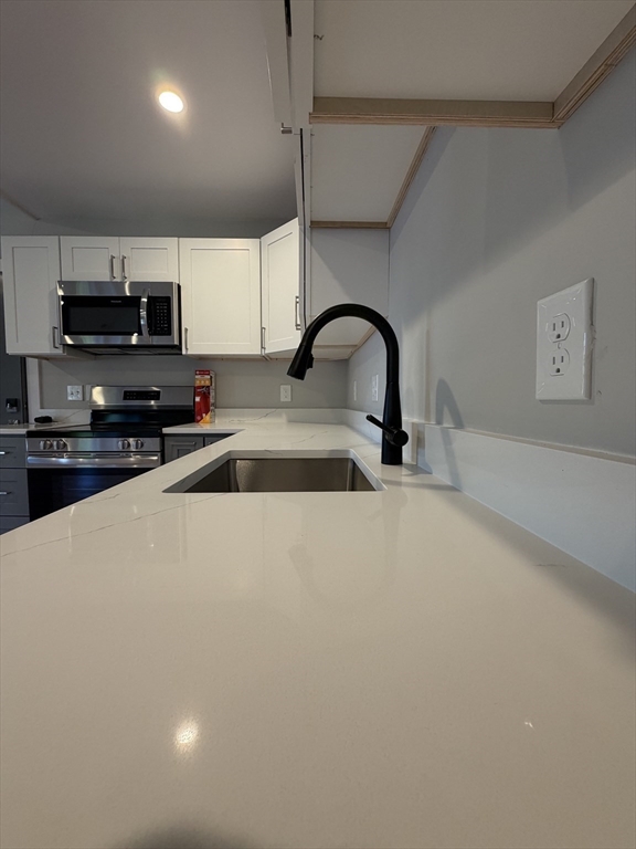944 East Street, Unit 3 Walpole, MA 02081 - Photo 8 of 23 a kitchen with stainless steel appliances a sink a stove top oven and a refrigerator