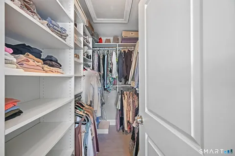 a view of walk in closet with clothes and shoes
