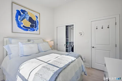 a bedroom with a bed and a painting on the wall