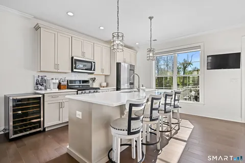 a kitchen with kitchen island granite countertop a stove a sink a dining table and chairs