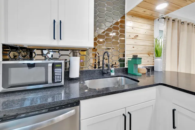 a kitchen with stainless steel appliances granite countertop a sink and a stove