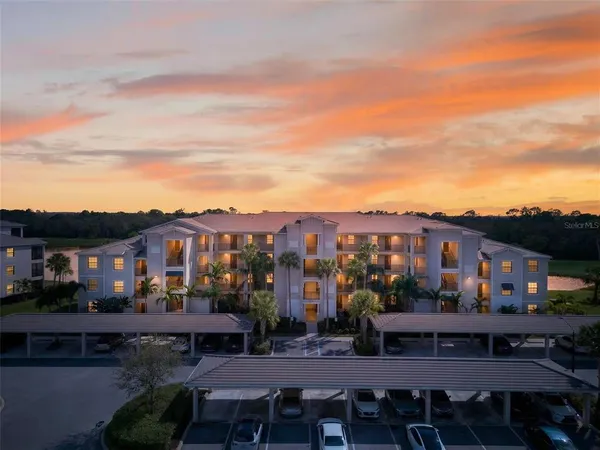 a view of a big house with a big yard and large trees