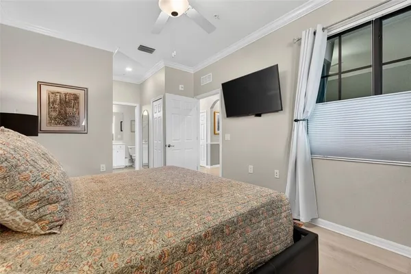 a spacious bedroom with a bed and a tv