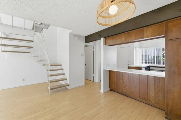 a view of a kitchen with wooden floor and iron stairs