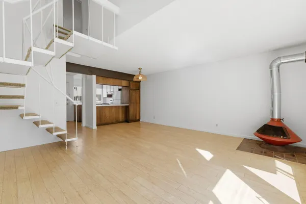 a view of empty room with wooden floor and cabinet