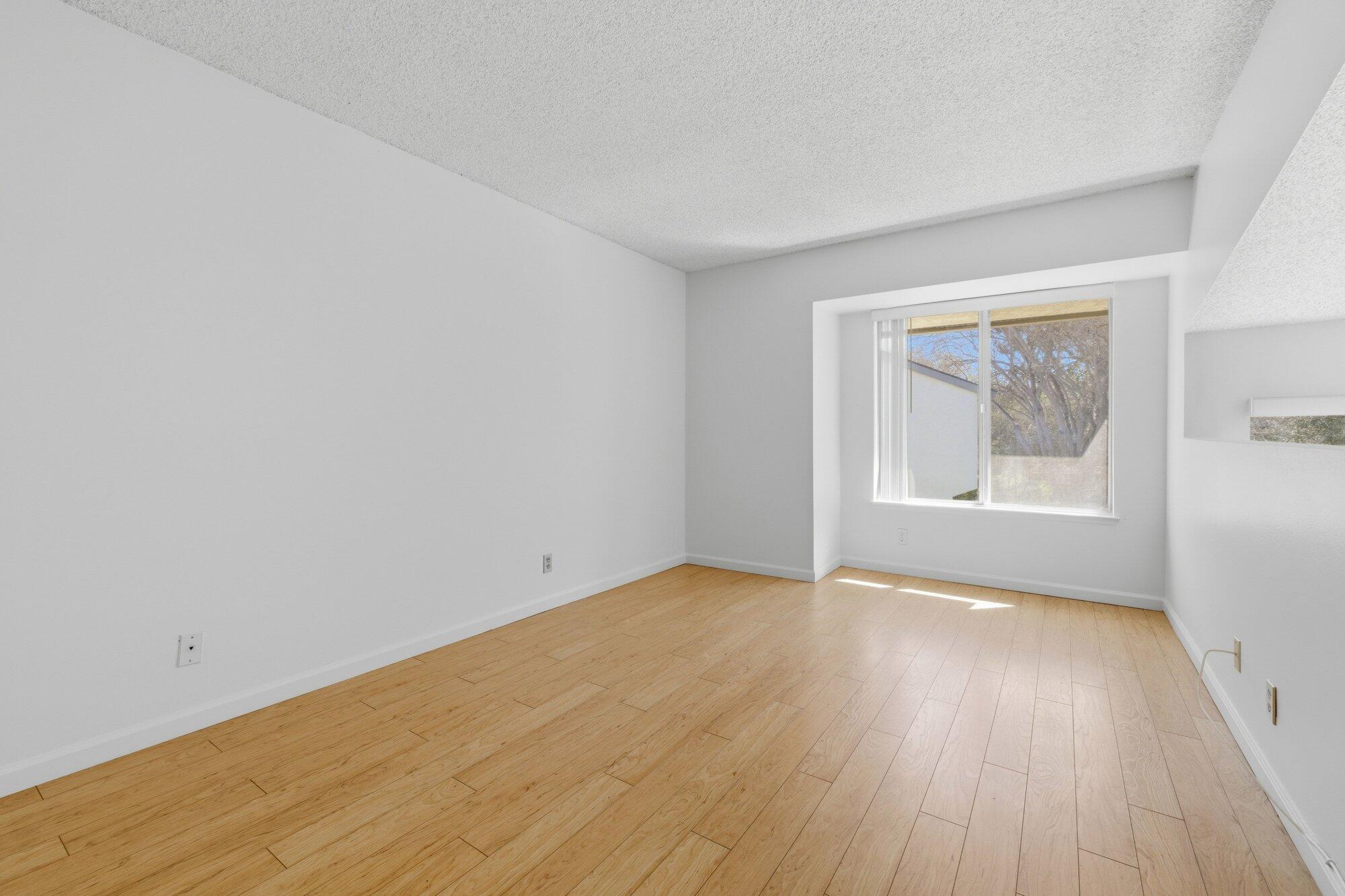 5455 8th Street, Unit 58 Carpinteria, CA 93013 - Photo 22 of 38 a view of an empty room with wooden floor and a window