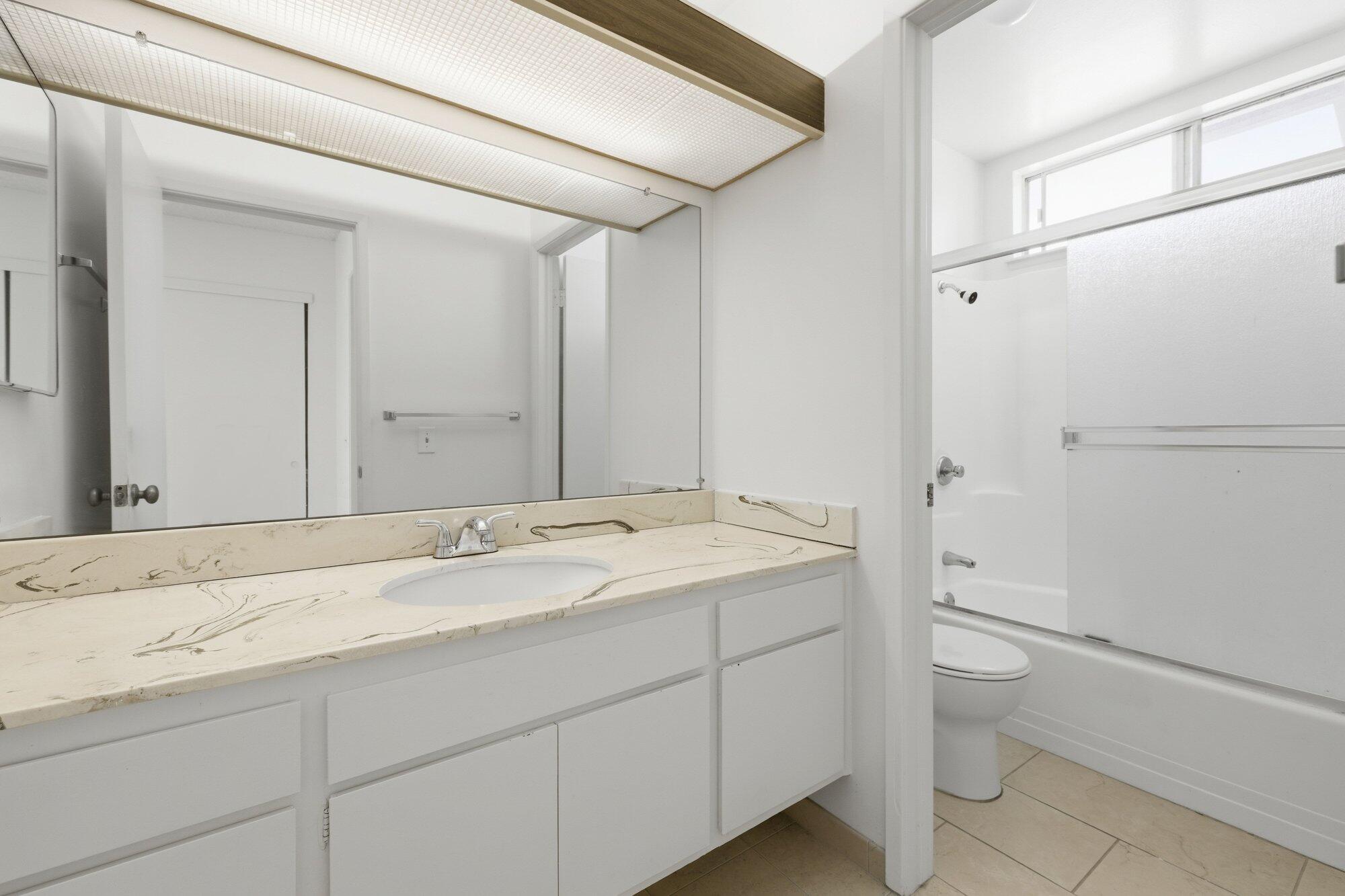 5455 8th Street, Unit 58 Carpinteria, CA 93013 - Photo 26 of 38 a bathroom with a granite countertop sink toilet and shower