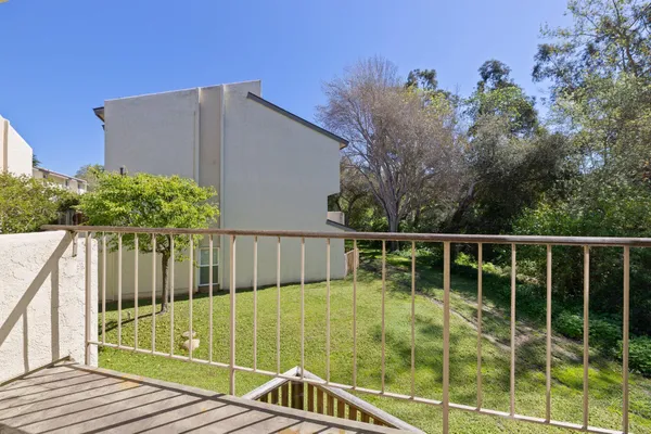 a view of a balcony with floor to ceiling window and wooden fence