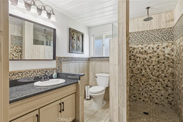 a bathroom with a granite countertop sink toilet and shower