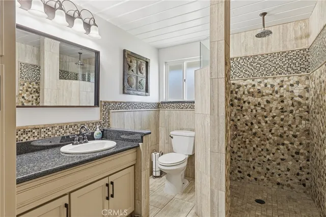a bathroom with a granite countertop sink toilet and shower