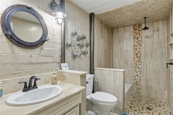 a bathroom with a sink a toilet and shower