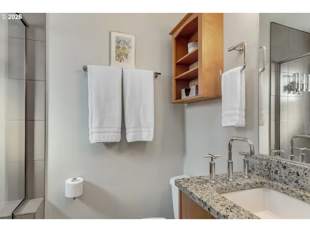 a bathroom with a granite countertop sink a toilet and a mirror