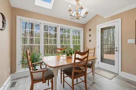 a dining room with furniture a chandelier and wooden floor