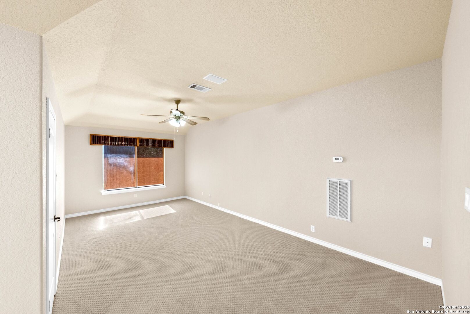 15921 Reyes Ridge Helotes, TX 78023 - Photo 27 of 68 an empty room with chandelier fan and windows