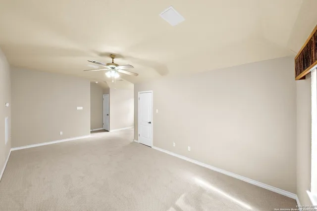 an empty room with a window and a ceiling fan