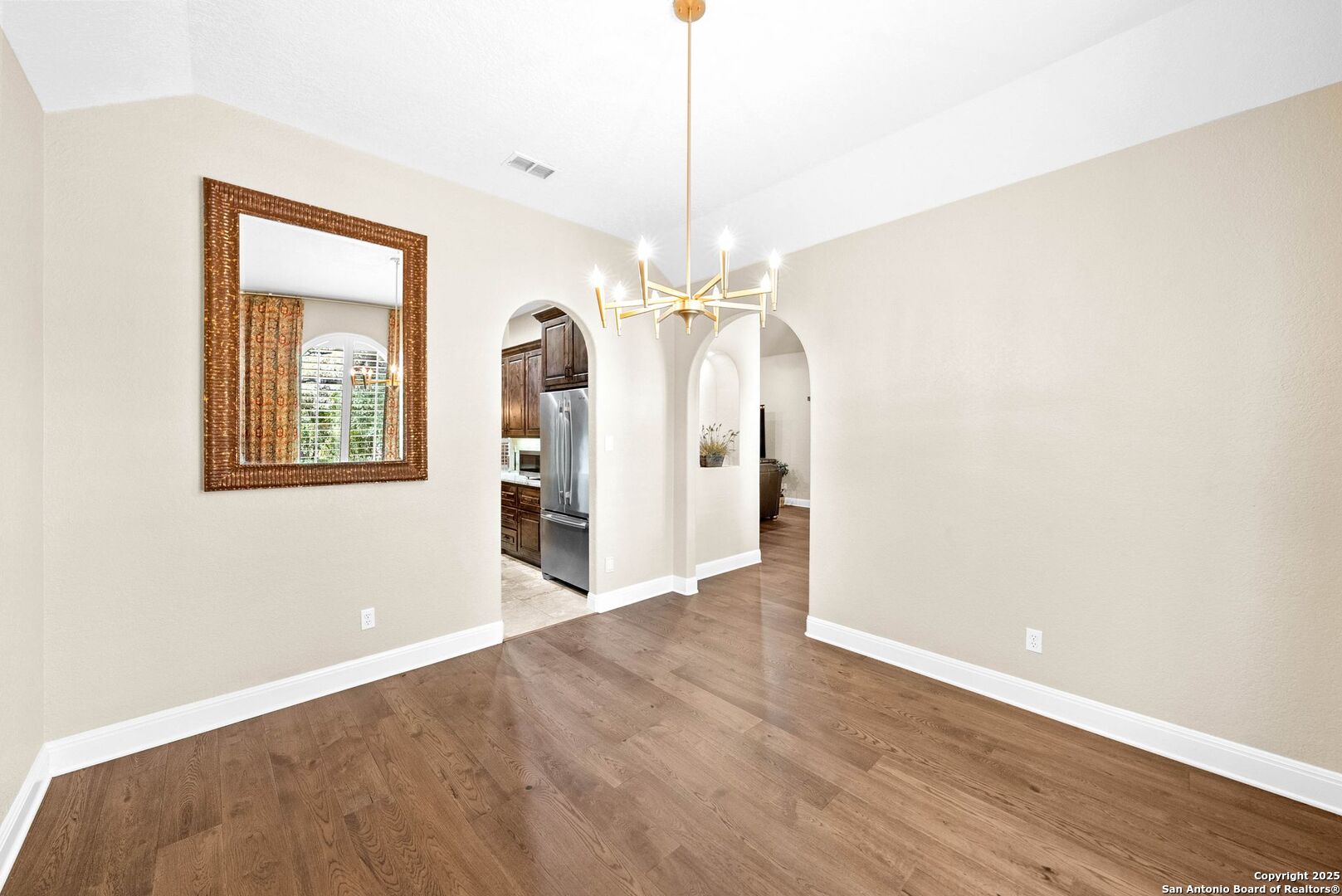 15921 Reyes Ridge Helotes, TX 78023 - Photo 32 of 68 a view of a hallway with wooden floor and a chandelier