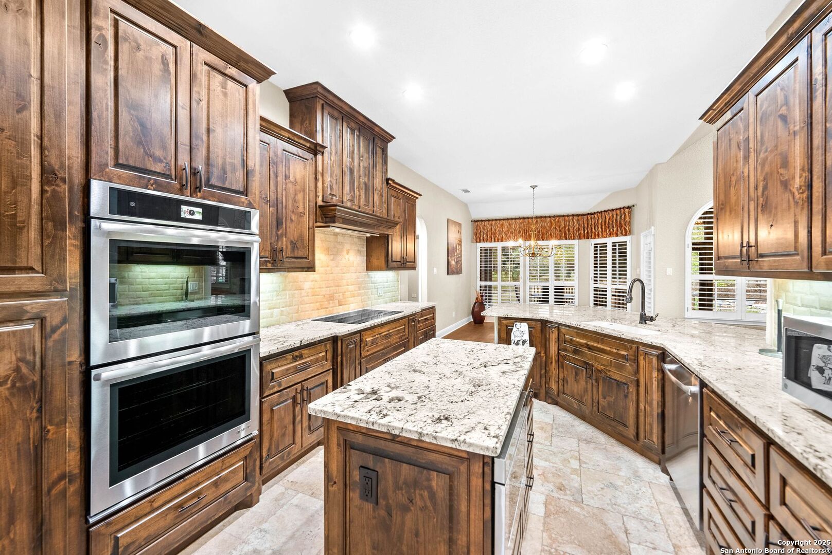 15921 Reyes Ridge Helotes, TX 78023 - Photo 10 of 68 a kitchen with stainless steel appliances kitchen island granite countertop a stove microwave and cabinets