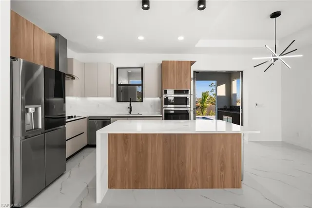a kitchen with stainless steel appliances a refrigerator and a sink