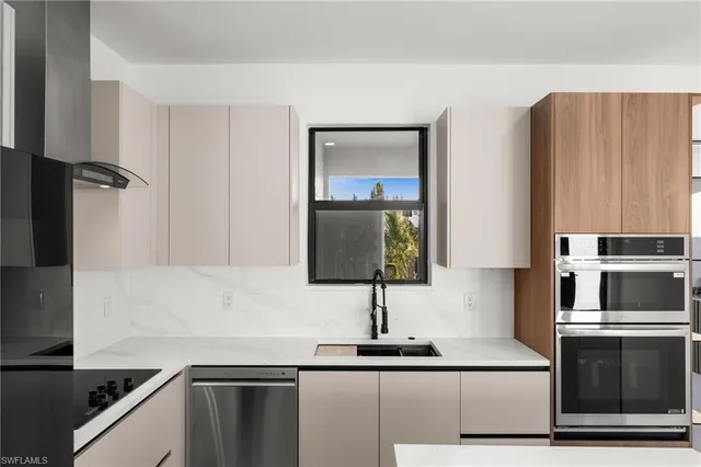 a kitchen with granite countertop a sink and a stove top oven with wooden floor